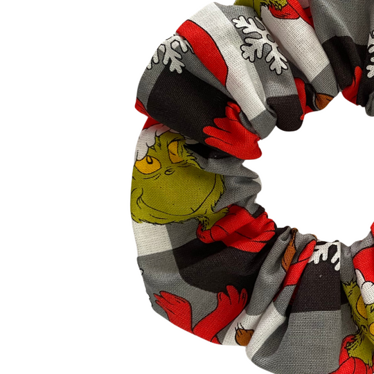 A black check fabric scrunchie with Grinch characters.