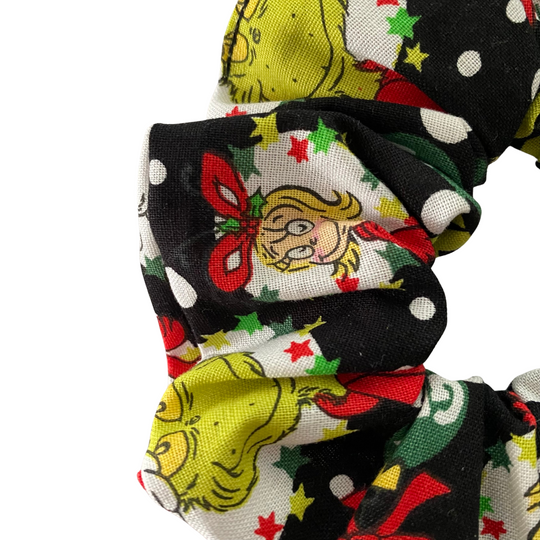 Close up view of a scrunchie with festive Grinch design on a white background.