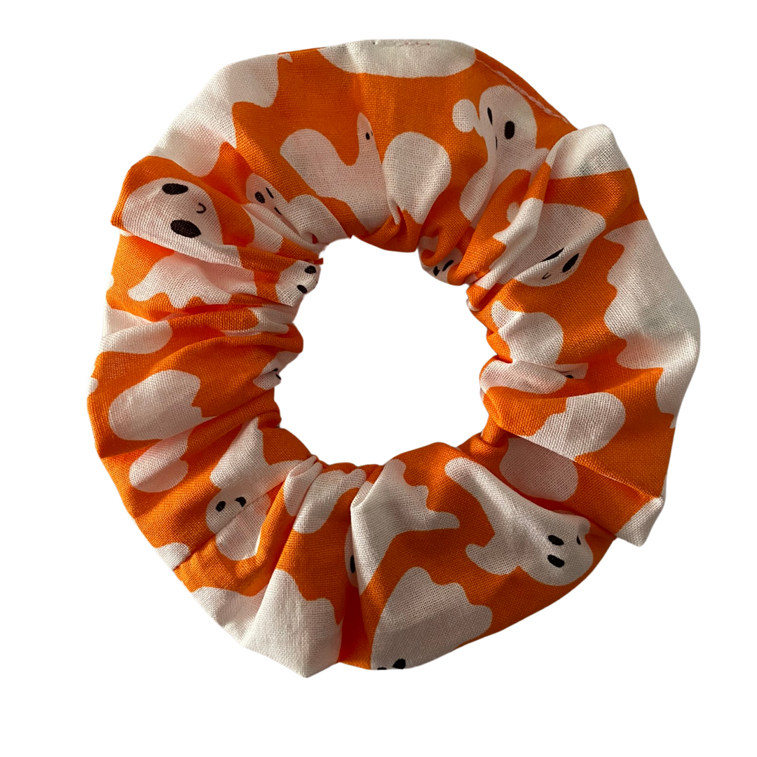 Halloween Scrunchie featuring white ghosts on orange soft cotton woven fabric.