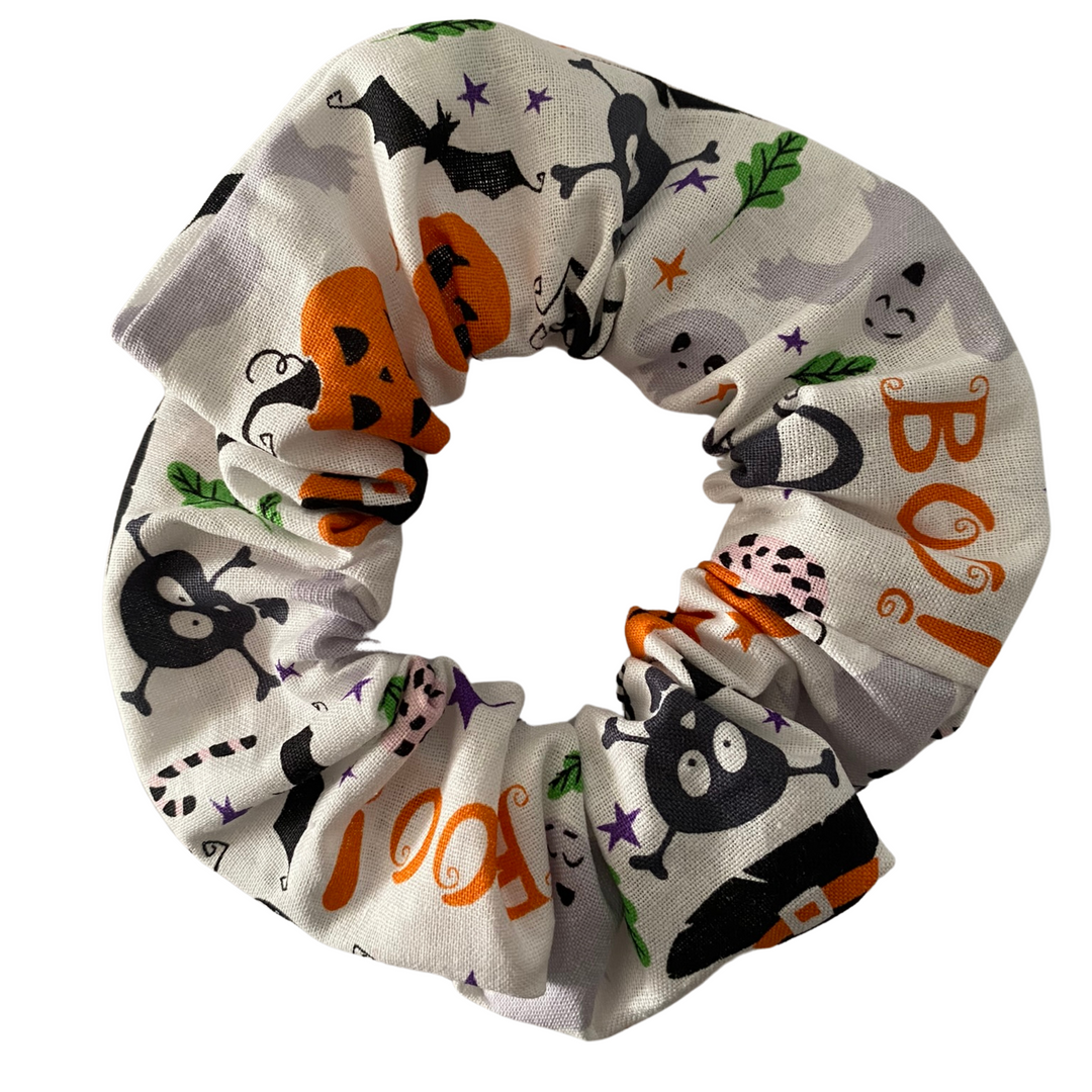 Halloween Scrunchie featuring jack-o’-lanterns, ghosts, skulls and bats on white soft cotton woven fabric.