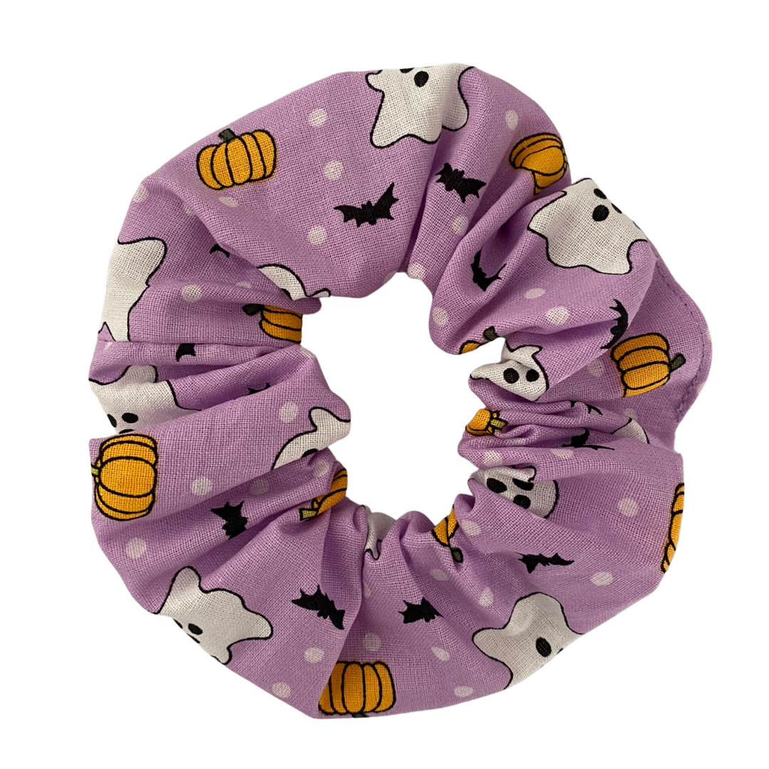 Halloween Scrunchie featuring playful ghosts, pumpkins, and black bats on lilac soft cotton woven fabric.