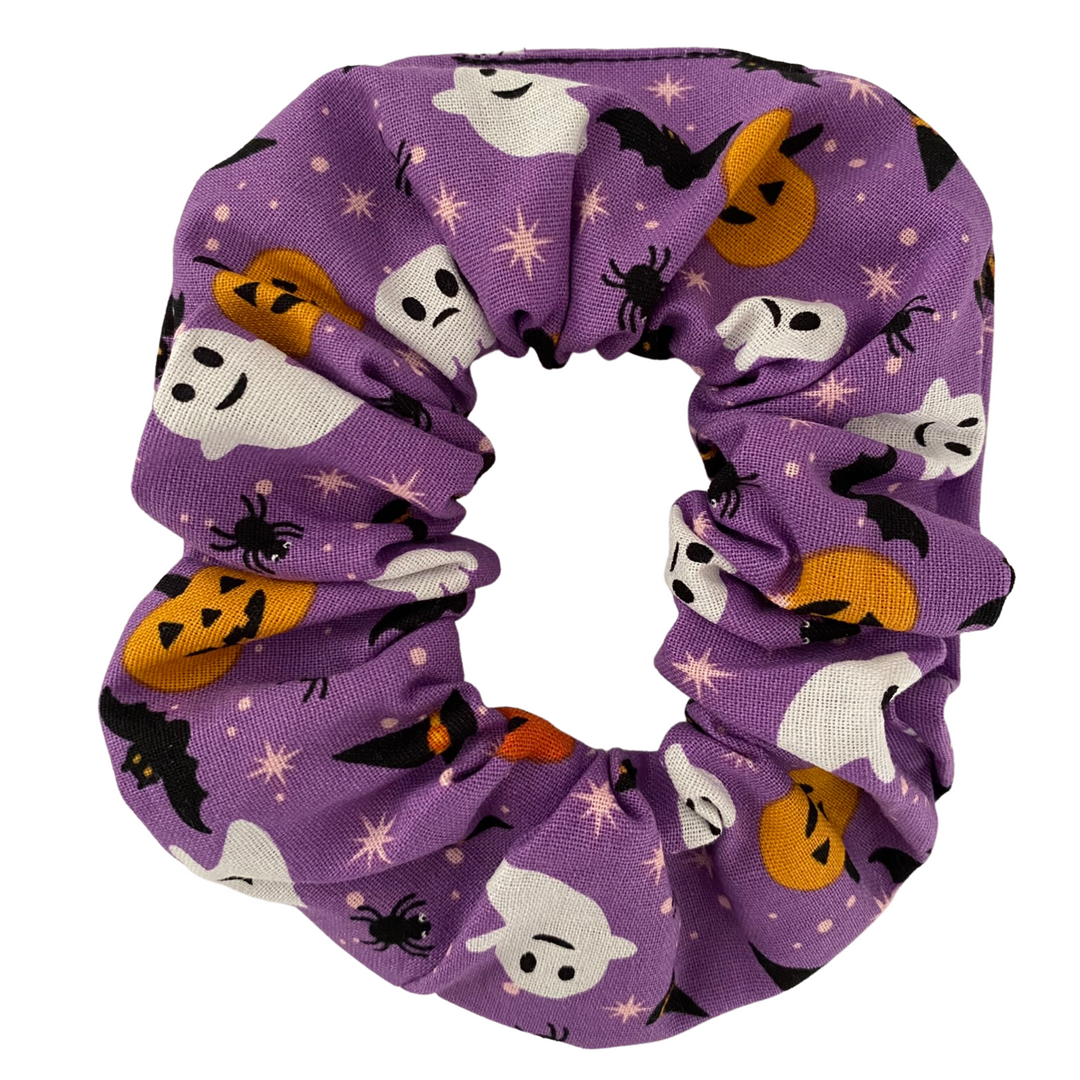 Halloween ghost mix scrunchie featuring bats, spiders, pumpkins and playful ghosts on purple soft cotton woven fabric.