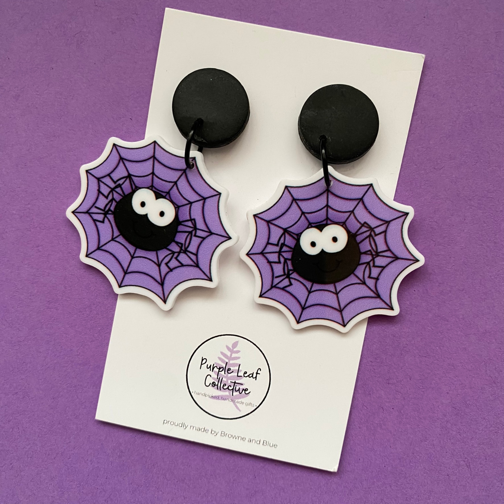 Spider web earrings on a card with 'Purple Leaf Collective' branding against a purple background.