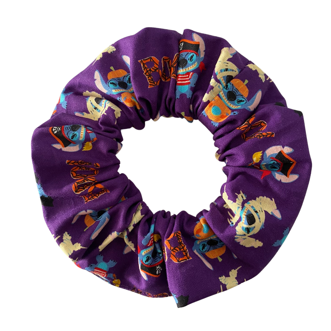Halloween Scrunchie featuring featuring adorable images of Stitch in fun Halloween costumes on purple soft cotton woven fabric.