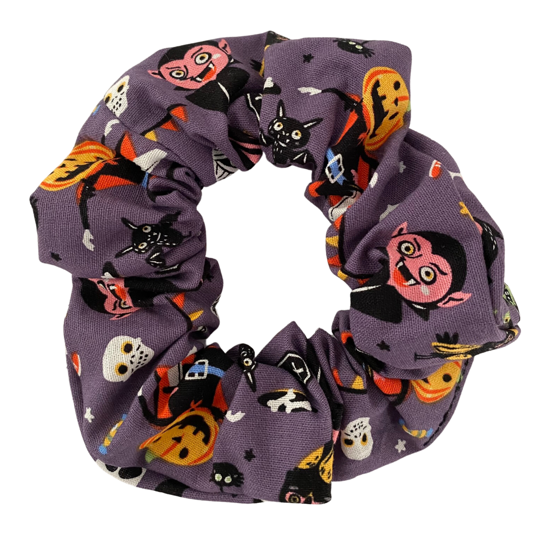 Halloween Trick or Treat Scrunchie! Featuring Dracula, a walking Jack-o’-Lantern, and other delightfully eerie images, on dark purple soft cotton woven fabric.