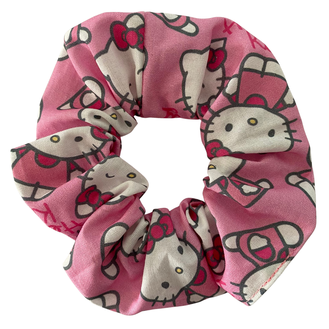 Pink scrunchie with cartoon character design on a white background.