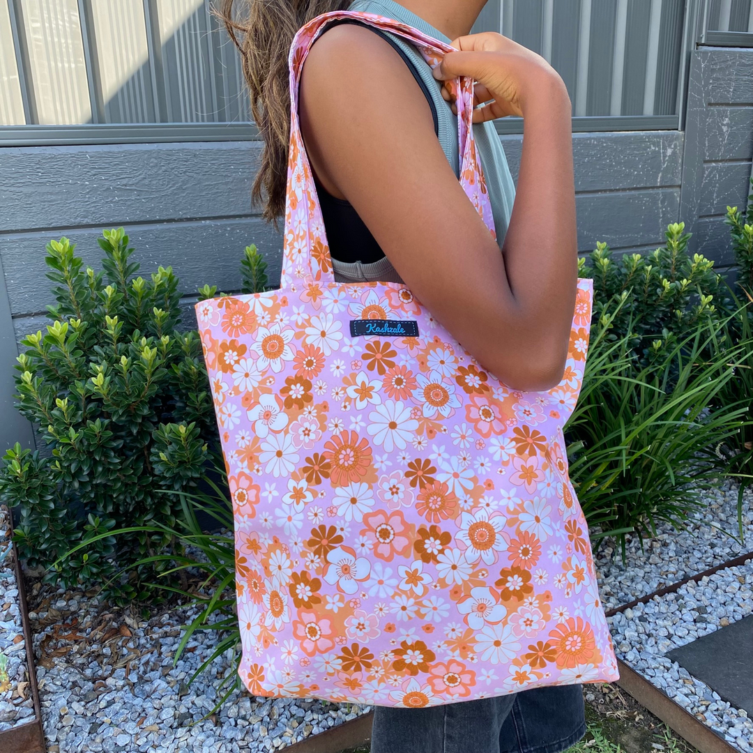 Retro Blooms Pink Blush reversible tote bag pictured on a customers shoulder, handmade with Jac Slade fabric. Washable, eco-friendly, and perfect for everyday use.