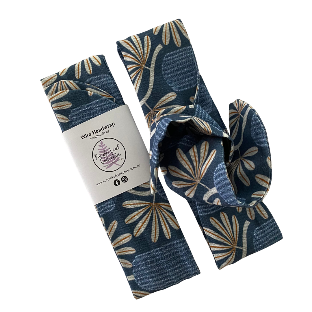 Wire headwrap features a banksia plant repeat pattern on a royal blue backdrop.