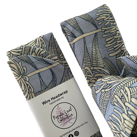 Close up view of a wire headwrap featuring a bone waratah repeat pattern on a soft blue-grey backdrop.