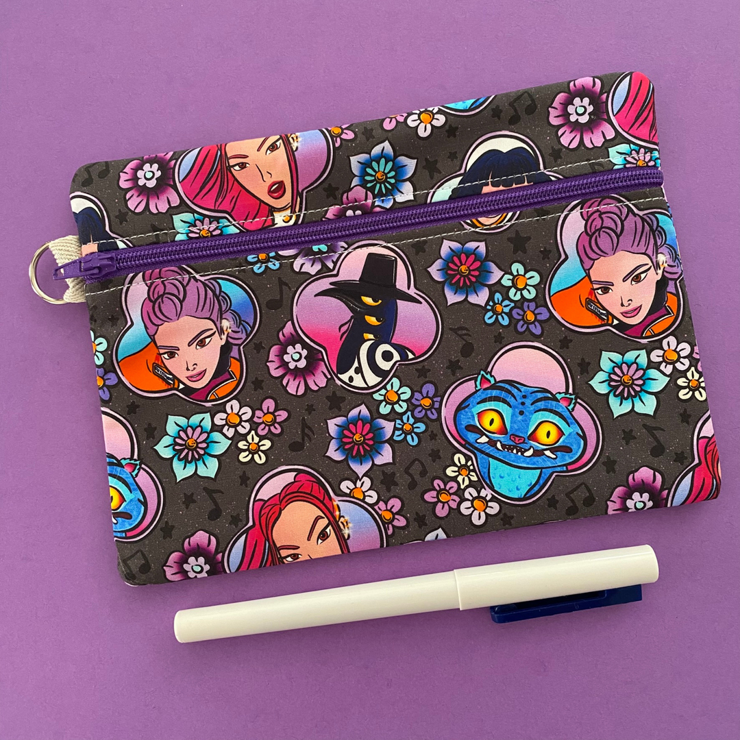 Colourful pouch with cartoon characters and flowers on a purple background.