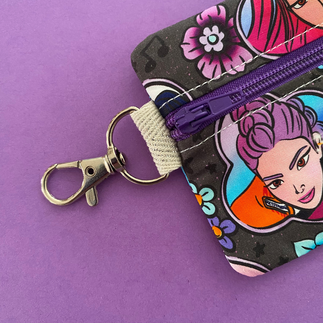 Clasp view of the mini pouch coin purse featuring images of K-Pop Demon Hunters on black fabric.