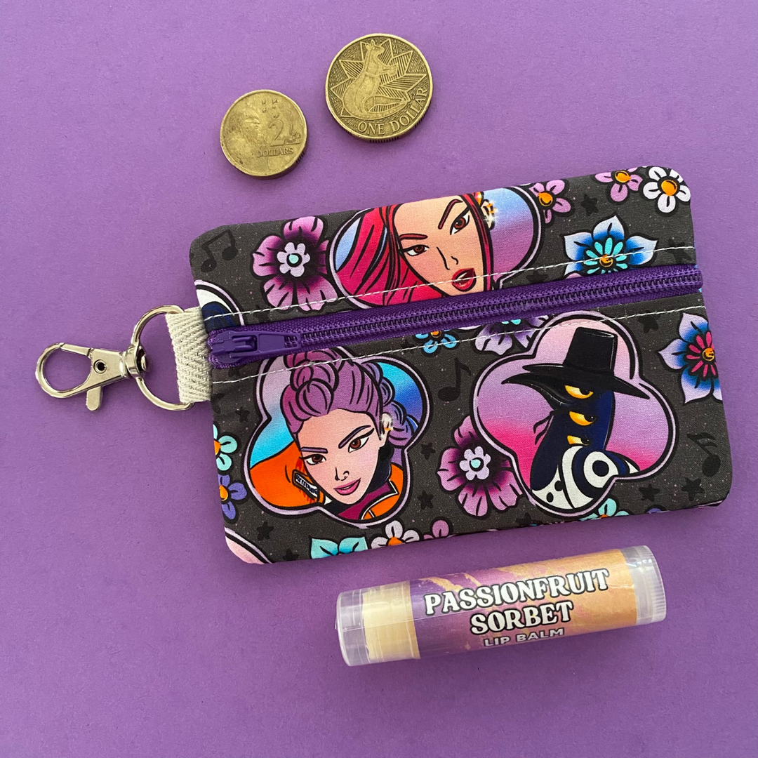 A mini pouch coin purse featuring images of K-Pop Demon Hunters on black fabric.