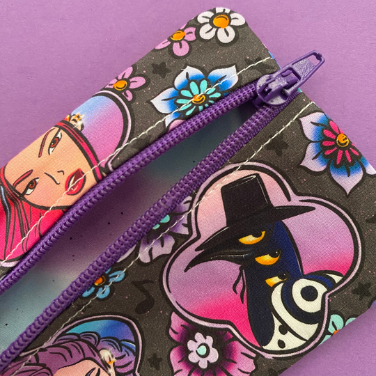 Lining view of the mini pouch coin purse featuring images of K-Pop Demon Hunters on black fabric.