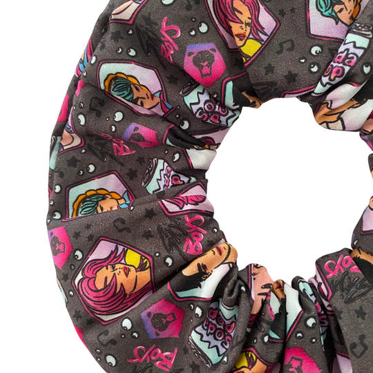 Detailed close up of K-Pop Demon Hunters Saja Boys Scrunchie. Featuring images of Jinu, Abby, Mystery, Romance and Baby along with cans of Soda Pop.