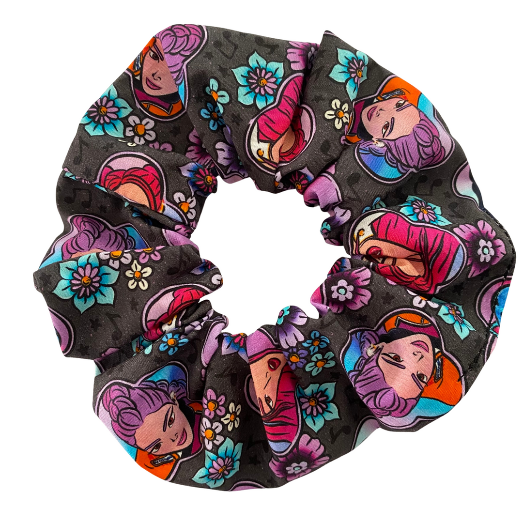A scrunchie featuring characters from K-Pop Demon Hunters on a black fabric.