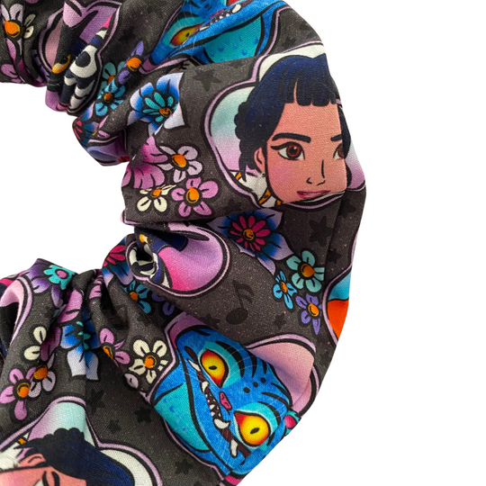 Close up view of a scrunchie featuring characters from K-Pop Demon Hunters on a black fabric.