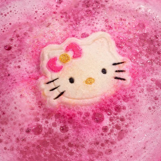 Hello Kitty face bath bomb fizzing in a pink bath.