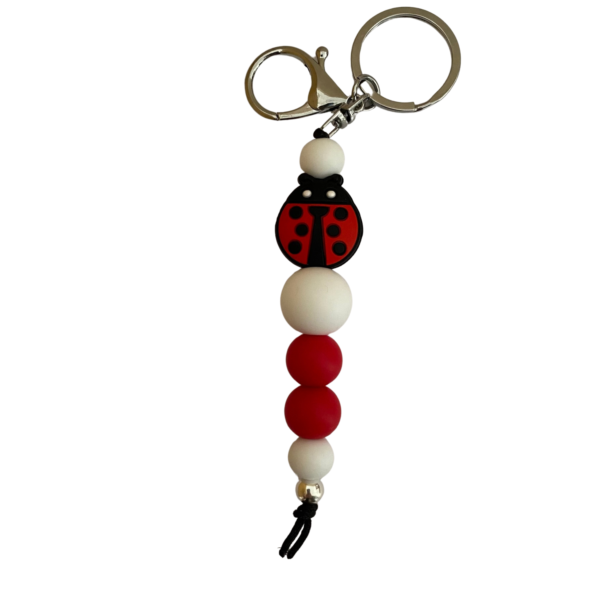 A keyring with a ladybug silicone bead and other round silicone beads.