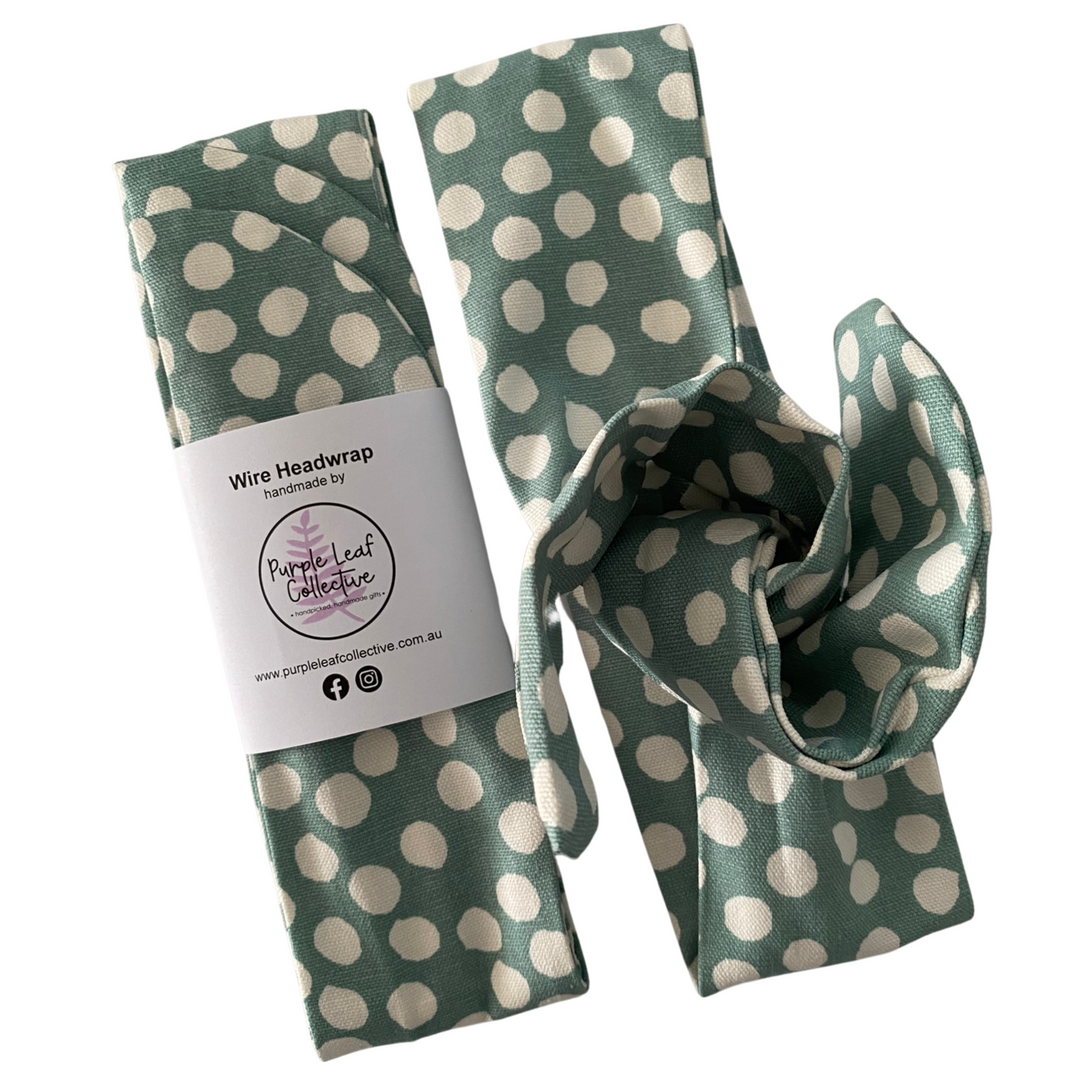 Green wire headwrap with white polka dots and a visible brand label on a white background.