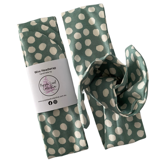 Green wire headwrap with white polka dots and a visible brand label on a white background.