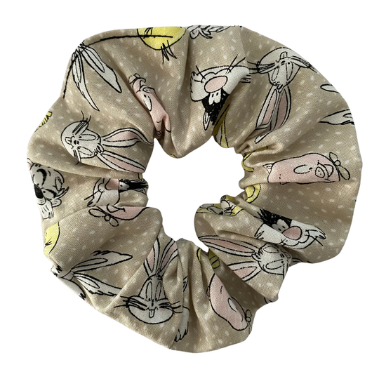Light grey cotton scrunchie featuring a whimsical pattern of Bugs Bunny, Tweety Bird and Daffy Duck.