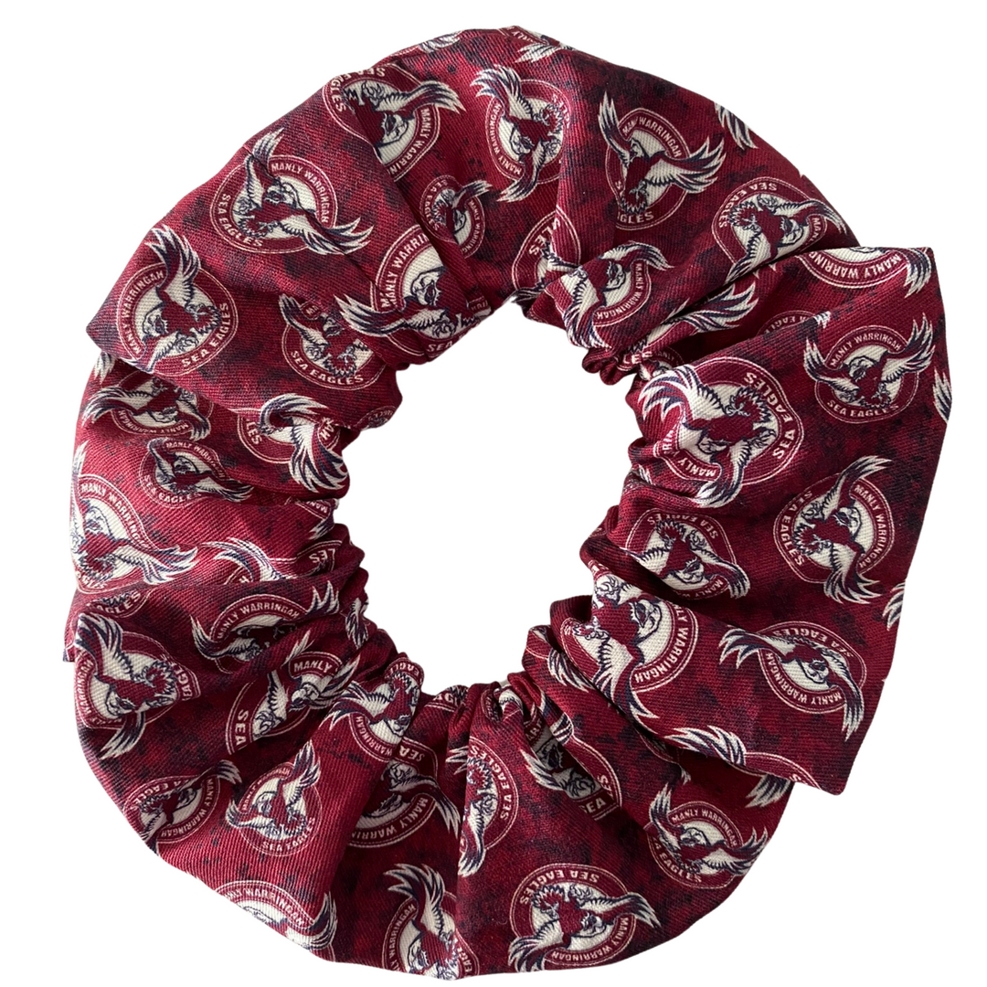 A scrunchie hair tie handmade with cotton woven fabric with images of the Manly-Warringah Sea Eagles rugby league team.