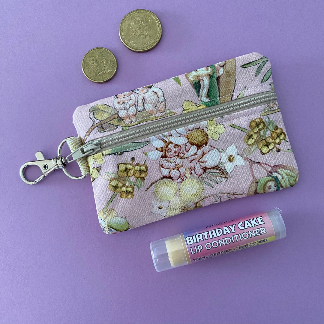 A small clip coin purse perfect for coins and small essentials featuring May Gibbs Gumnut Babies on pink fabric.