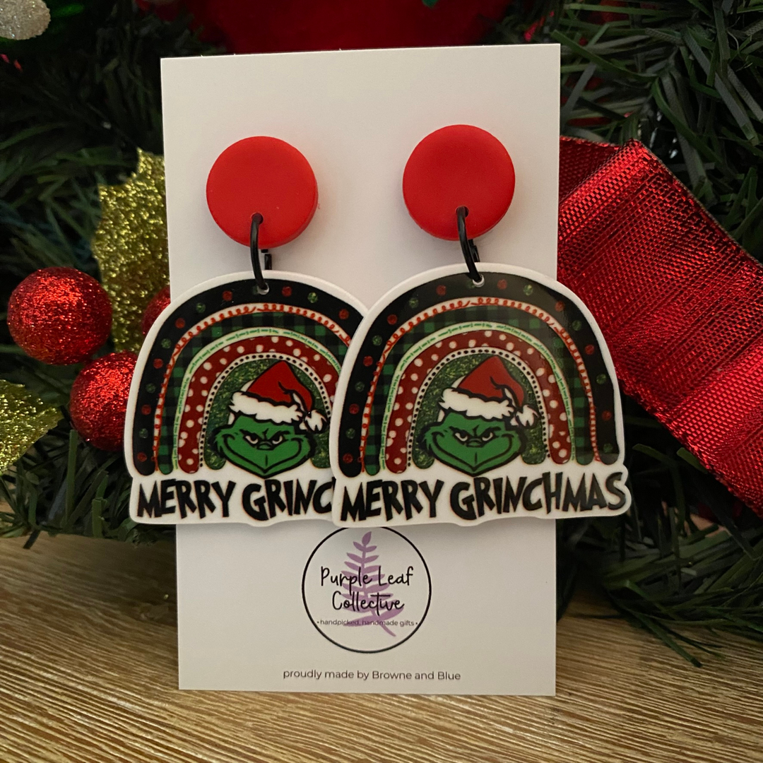 Merry Grinchmas Rainbow Christmas earrings on a card with festive background.