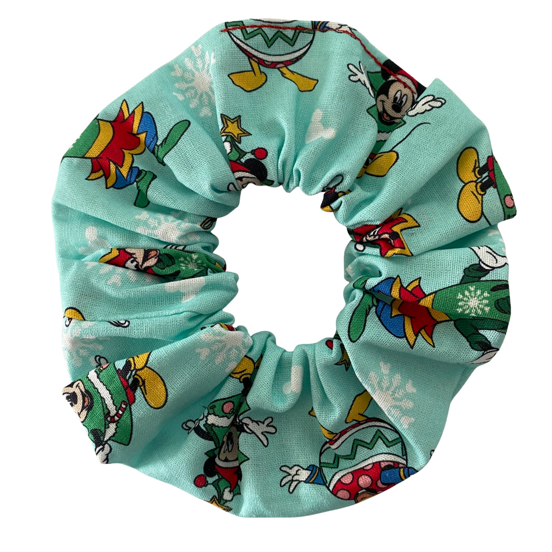 Scrunchie with Mickey, Minnie, Goofy, Donald, Daisy character pattern on a light blue background.