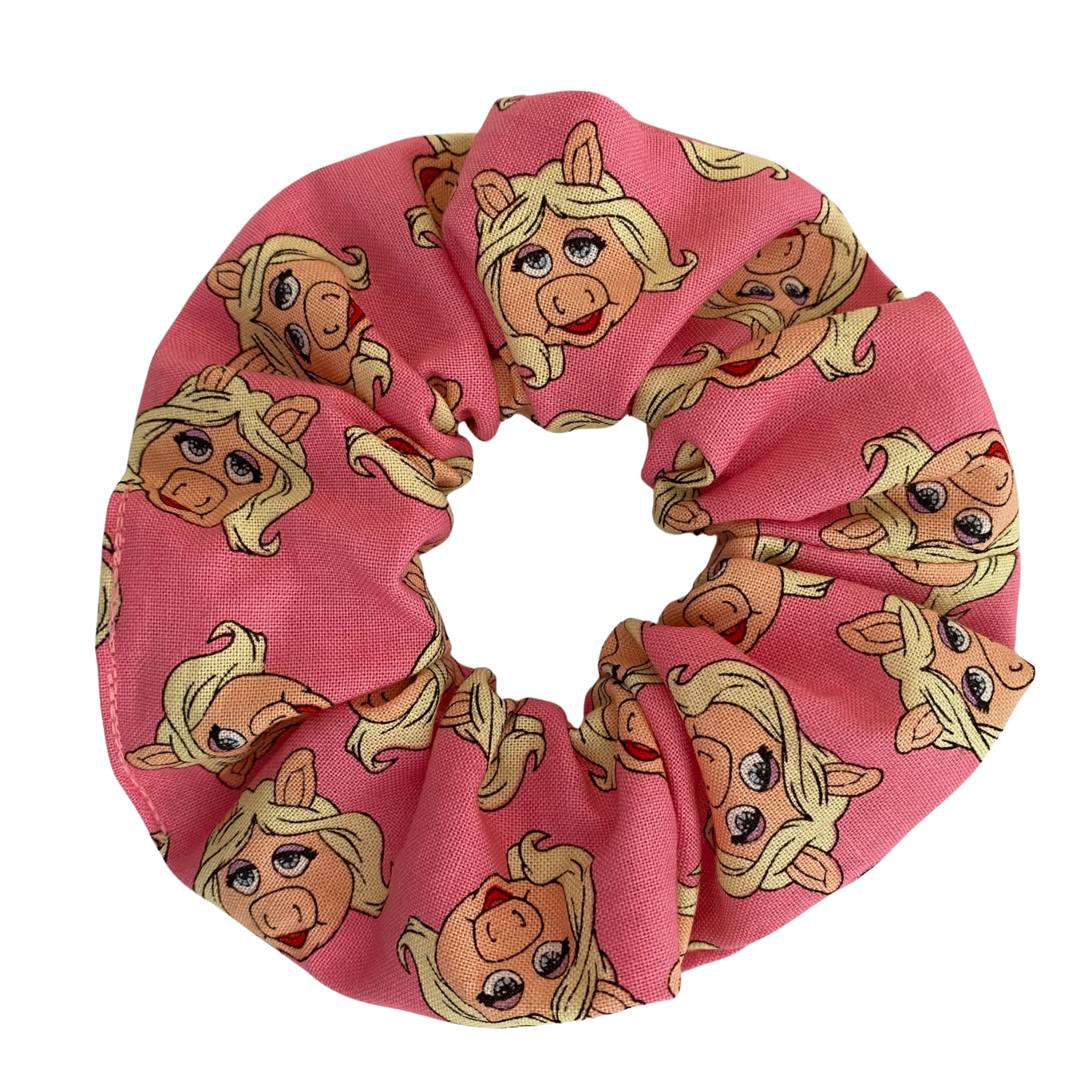 Miss Piggy Scrunchie showcasing fun and fabulous illustrations of Miss Piggy on a pink background featuring durable braided elastic for secure styling.