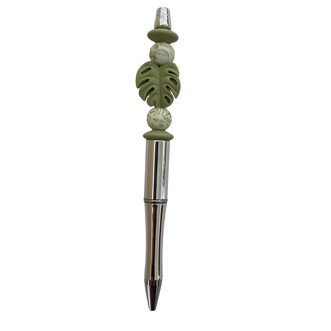 Decorative pen with Monstera Leaf beads on a white background.