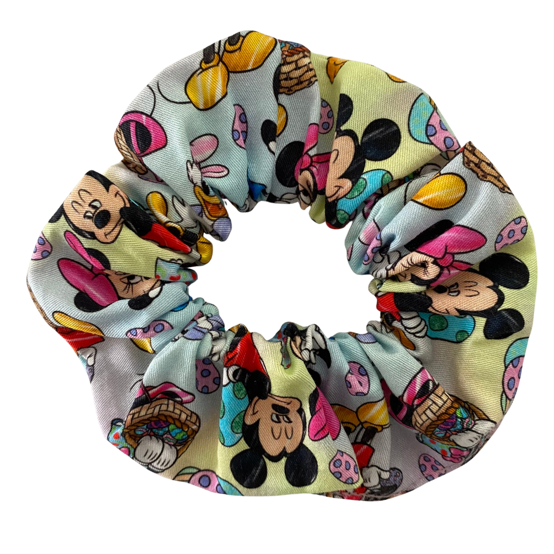 Scrunchie with illustrations of Mickey, Minnie, Donald, Daisy and Pluto surrounded by pastel-toned Easter eggs.
