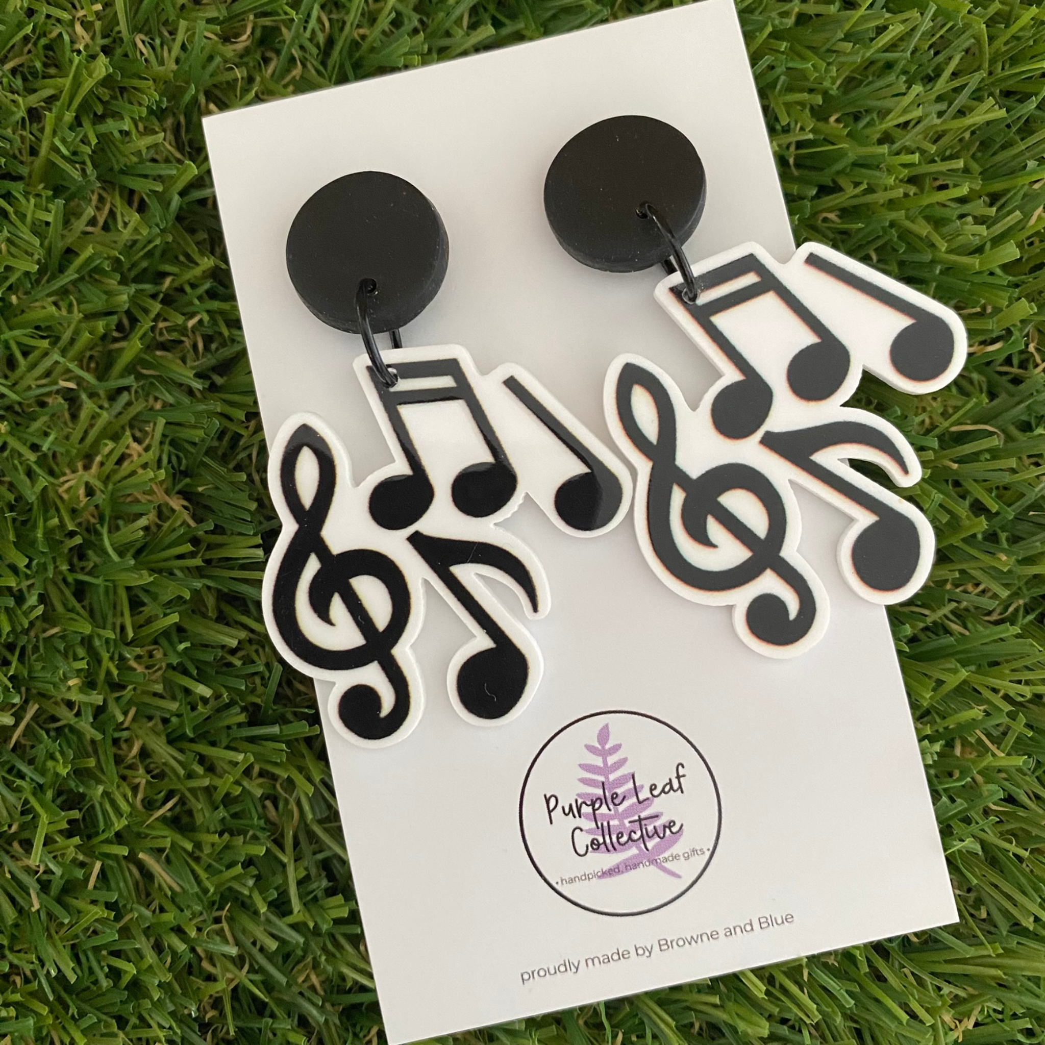 Pair of earrings with musical note designs set on black stud tops.