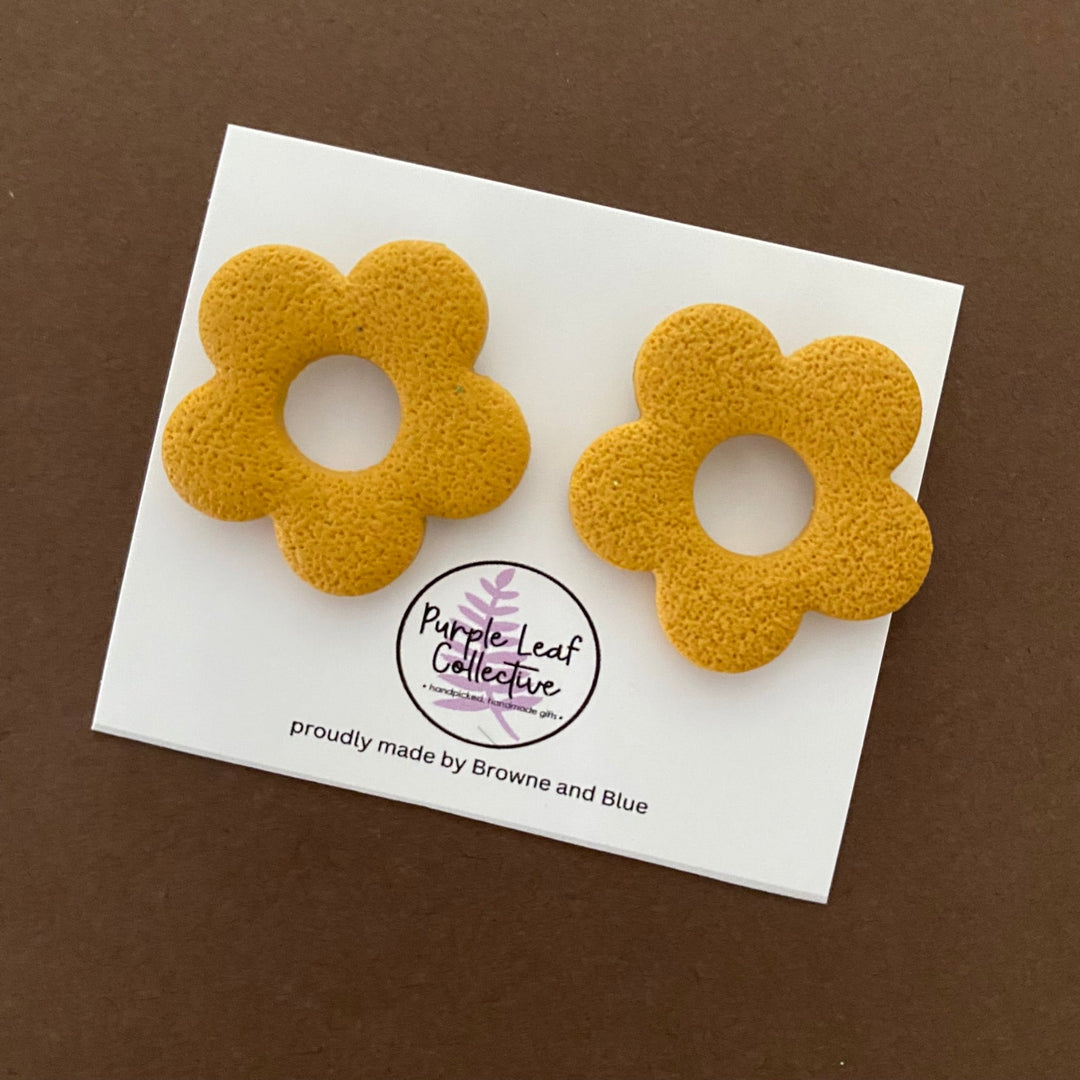 Drop stud earrings with five mustard polymer clay flower petals, set on surgical steel posts for comfort and durability.