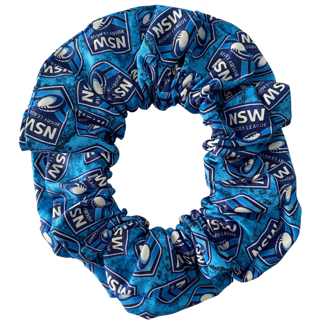 A scrunchie hair tie handmade with cotton woven fabric with images of the New South Wales Blues rugby league team.