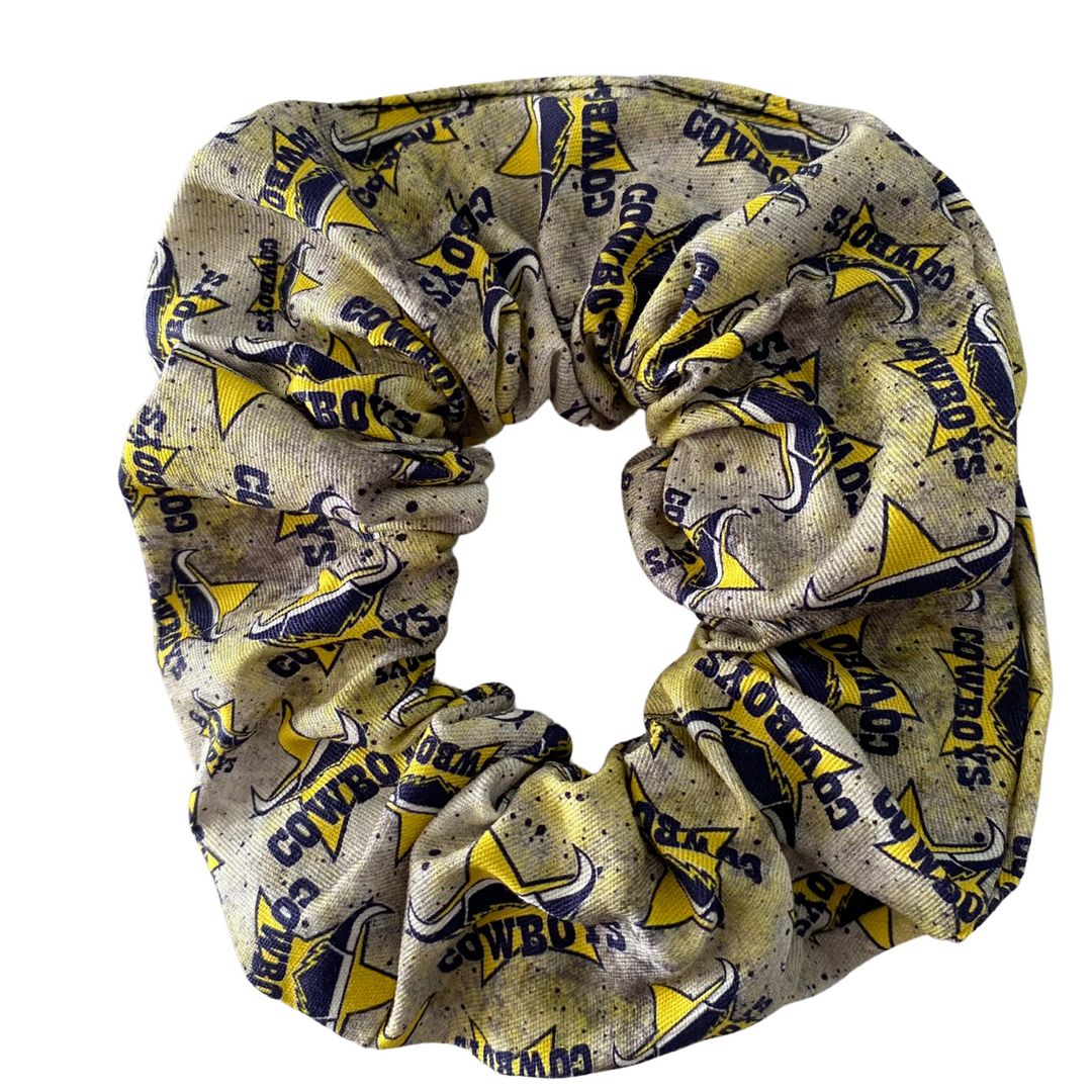 A scrunchie hair tie handmade with cotton woven fabric with images of the North Queensland Cowboys rugby league team.