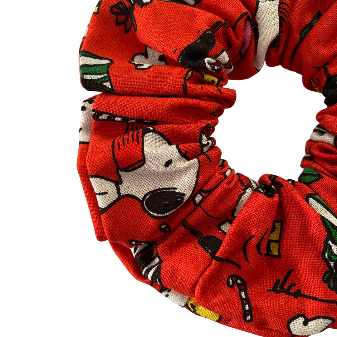 Close up view of Images of Snoopy and other festive designs on a red fabric.