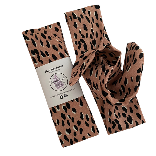 Pink leopard print wire headwrap with packaging on a white background.