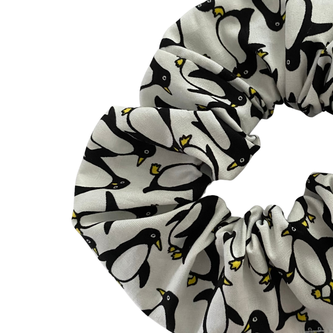 A white fabric scrunchie featuring penguins.