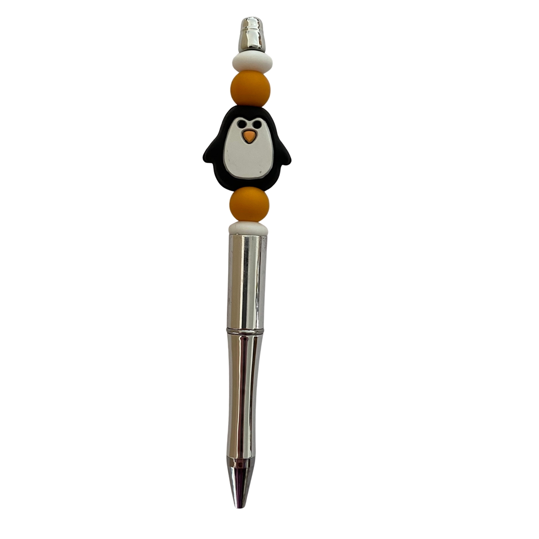 Penguin-shaped pen with a silver clip on a white background.