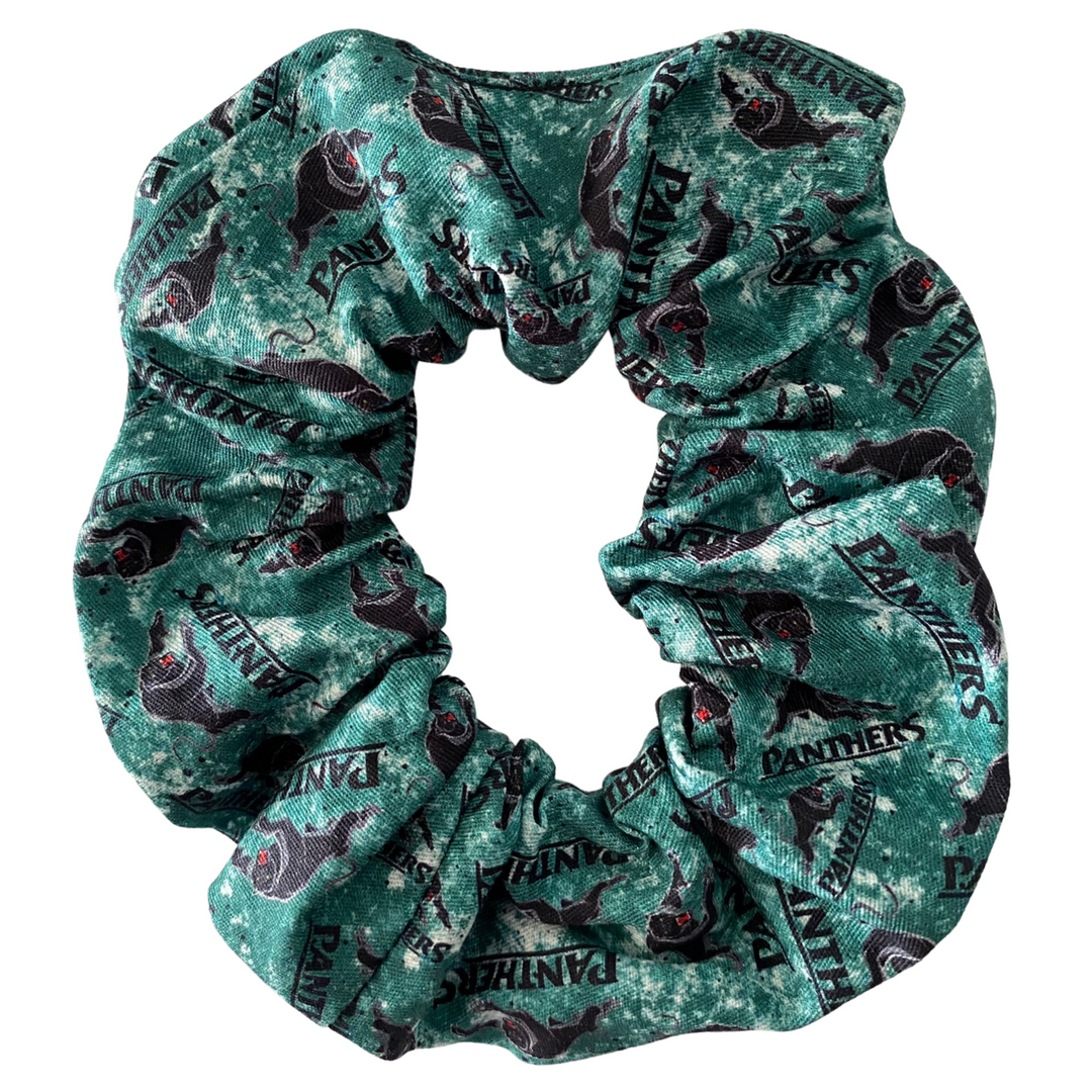 A scrunchie hair tie handmade with cotton woven fabric with images of the Penrith Panthers rugby league team.