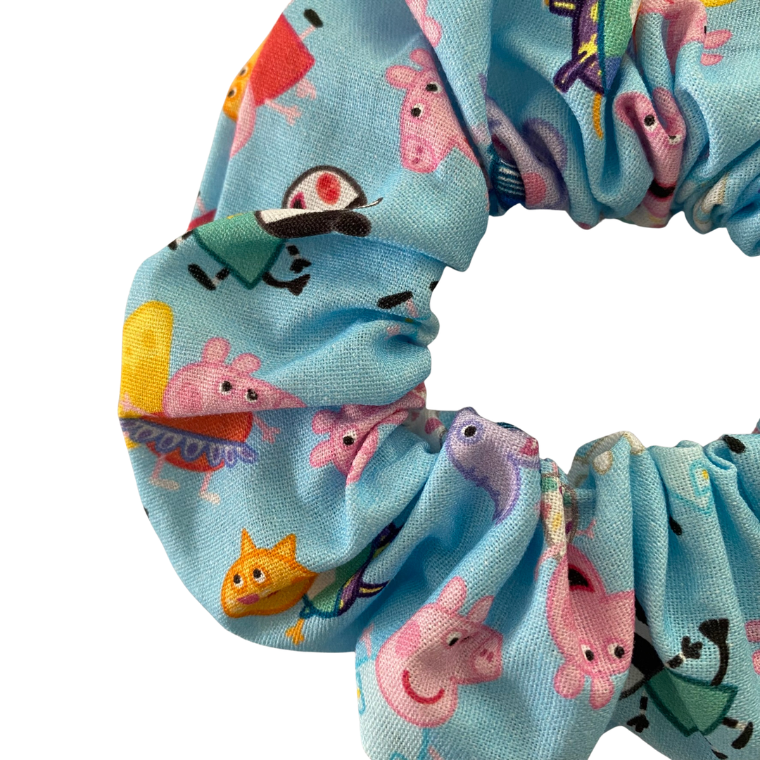 Peppa Pig characters on a blue fabric scrunchie.