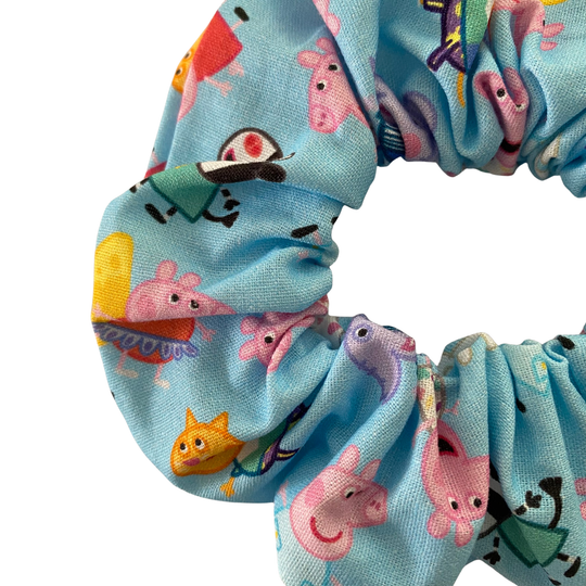 Peppa Pig characters on a blue fabric scrunchie.