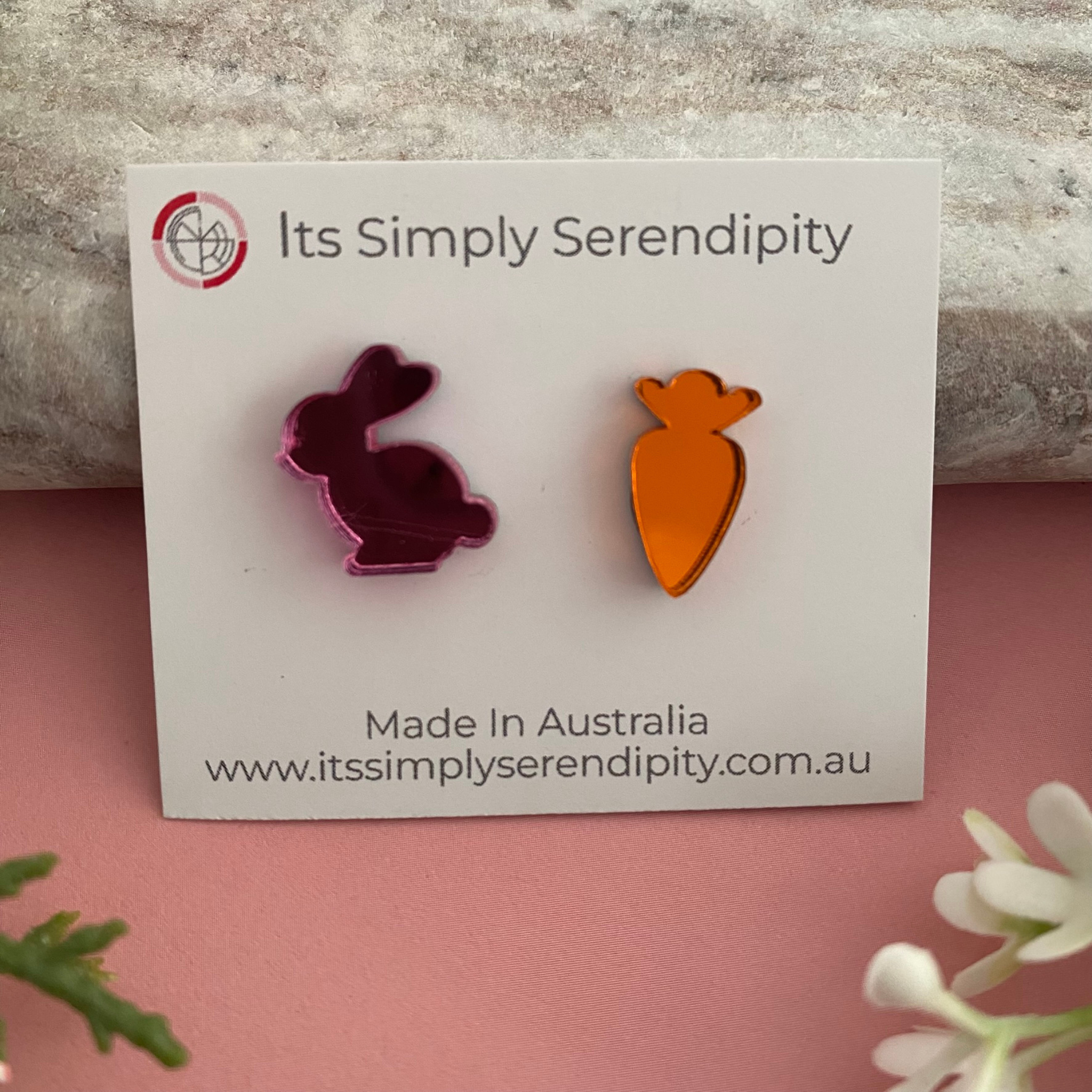 Pink bunny and carrot shaped earrings made from a vibrant mirrored acrylic.