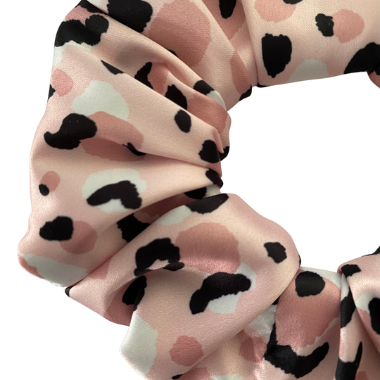 Pink scrunchie with animal print pattern on a white background.