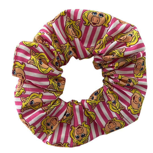 Pink and white striped scrunchie with pig face pattern on a white background.