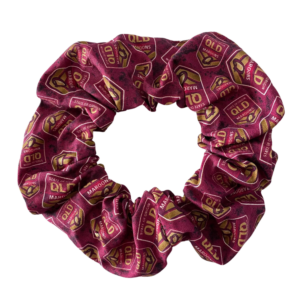 A scrunchie hair tie handmade with cotton woven fabric with images of the Queensland Maroons rugby league team.