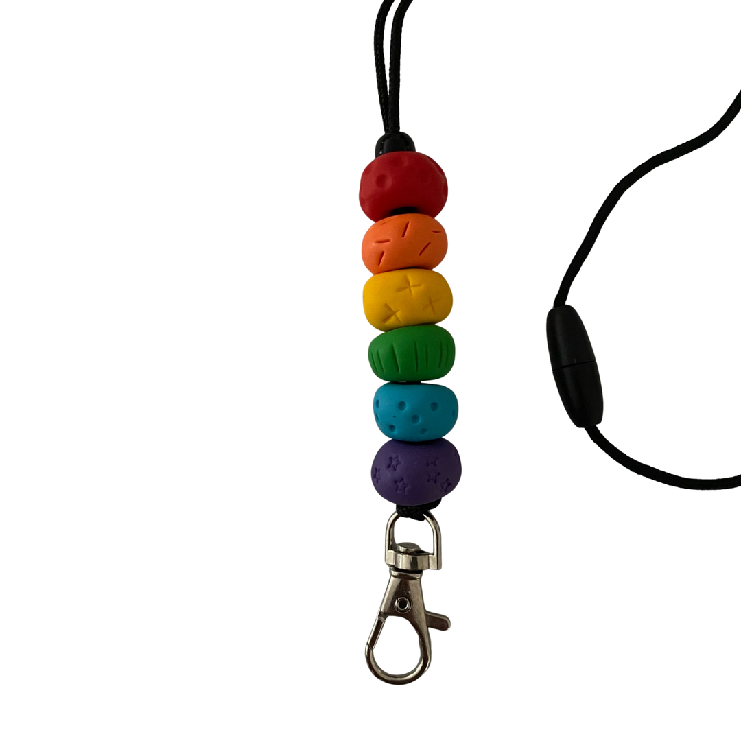 Handmade polymer clay lanyard with six hand-rolled beads in red, orange, yellow, green, blue and purple colours. Threaded on a nylon cord with a breakaway safety clasp and a silver-plated clip.