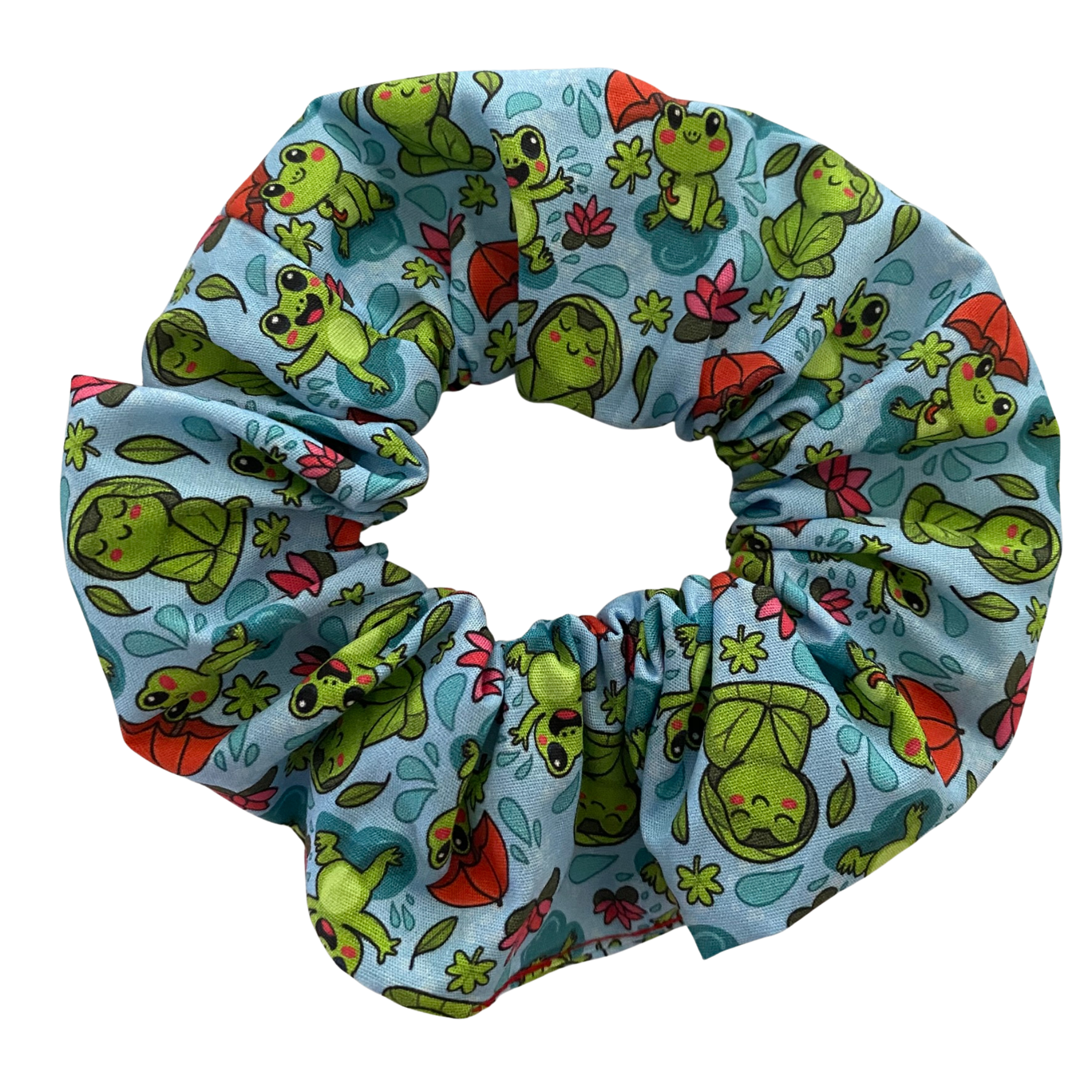 A blue fabric scrunchie with images of frogs in the rain holding umbrellas and sitting on lily pads.