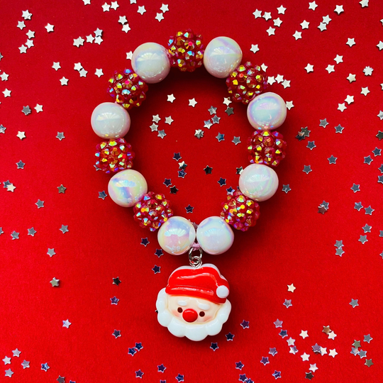 A beaded Christmas bracelet featuring white iridescent opal-like beads, red rhinestone-covered beads, and a Santa Claus face charm.